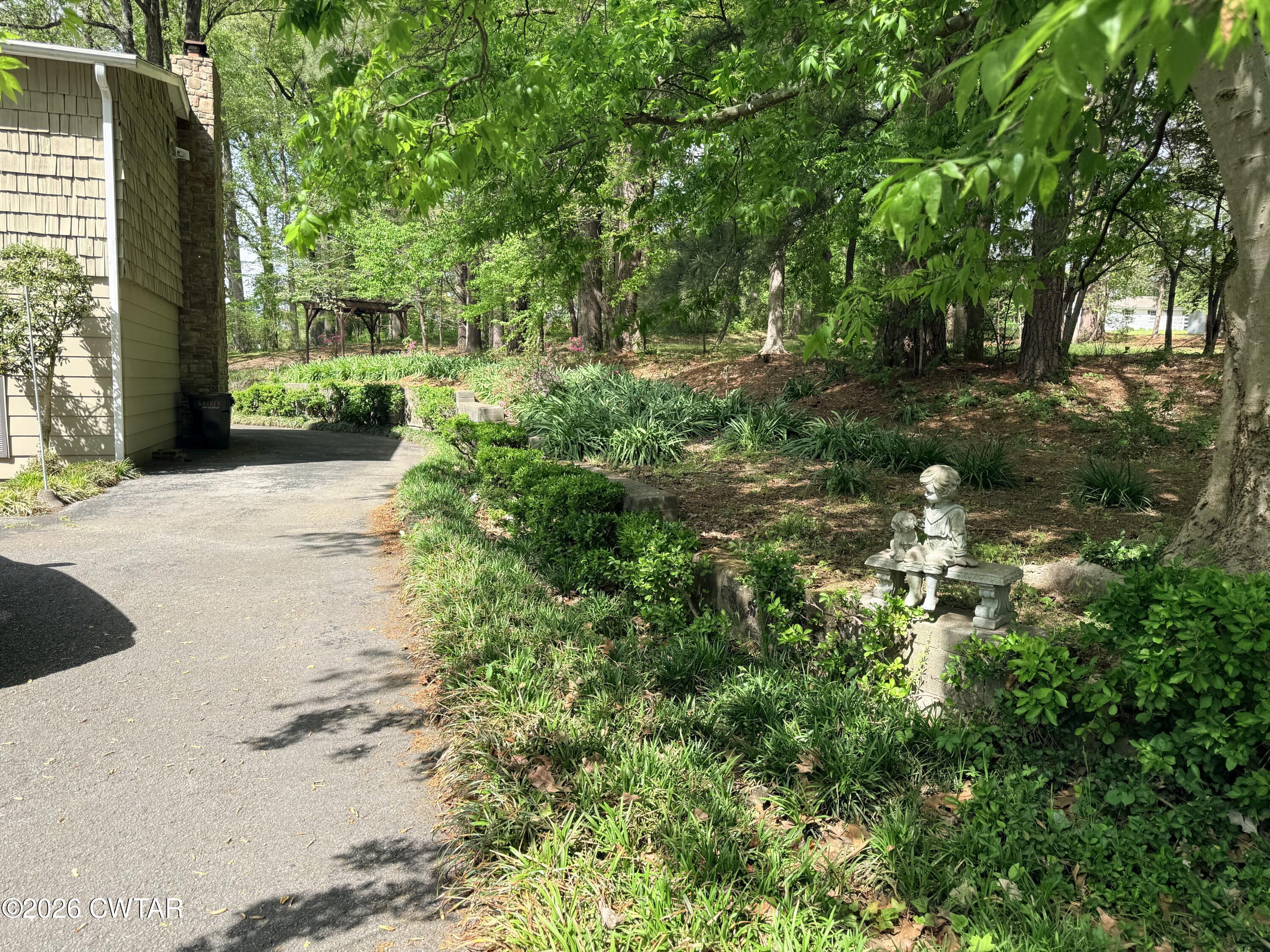 261 Lackey Lane Ripley, TN 38063 - Photo 38 of 48 a backyard of a house with lots of green space and fountain in the back