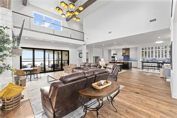 a living room with stainless steel appliances kitchen island a table and chairs in it