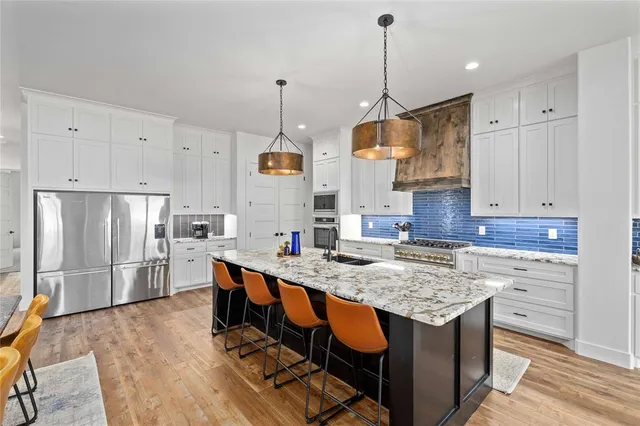 a kitchen with granite countertop white cabinets and white appliances