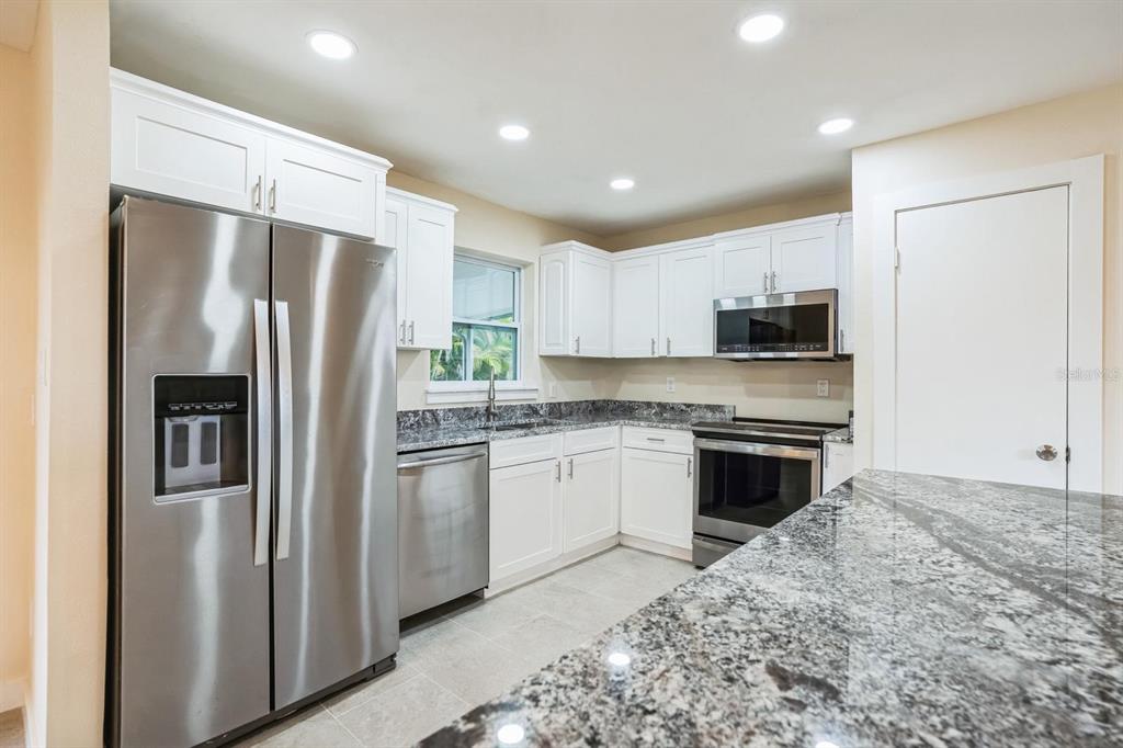 6064 Park Road Fort Myers, FL 33908 - Photo 2 of 14 a kitchen with stainless steel appliances granite countertop a refrigerator sink and stove