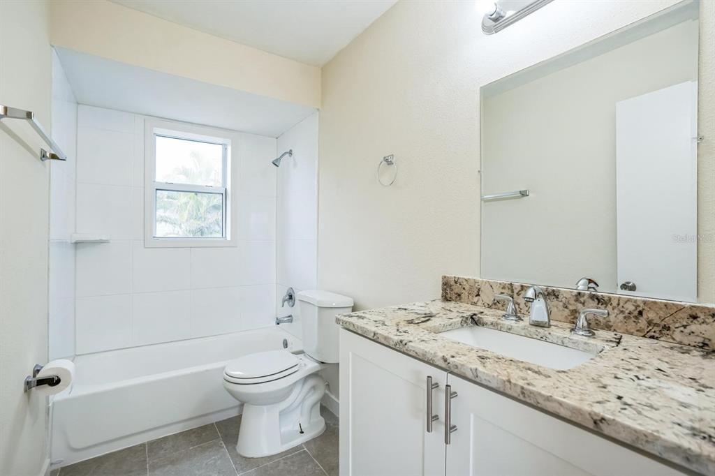 6064 Park Road Fort Myers, FL 33908 - Photo 8 of 14 a bathroom with a granite countertop toilet a sink and a bathtub