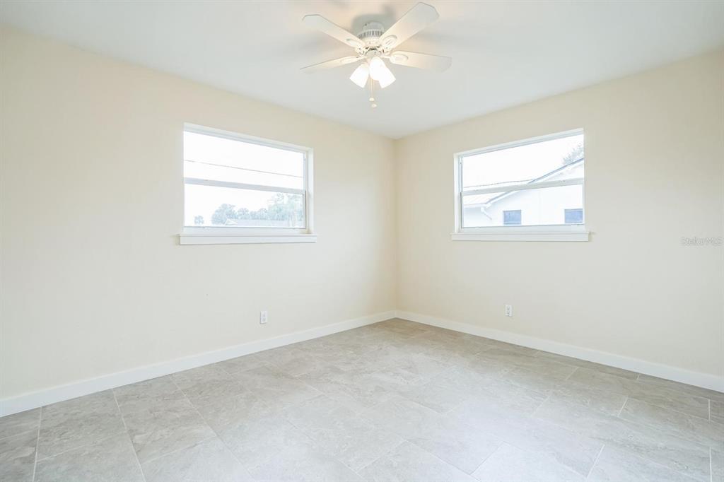 6064 Park Road Fort Myers, FL 33908 - Photo 10 of 14 an empty room with a window and a fan