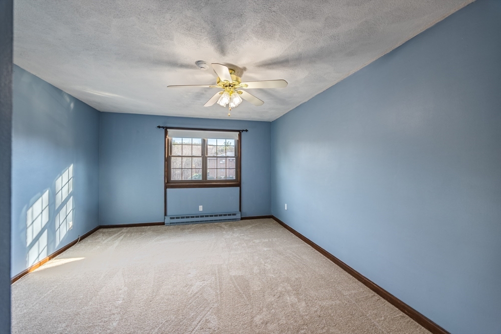 41 Spencer Road, Unit 26G Boxborough, MA 01719 - Photo 24 of 35 an empty room with windows and chandelier fan