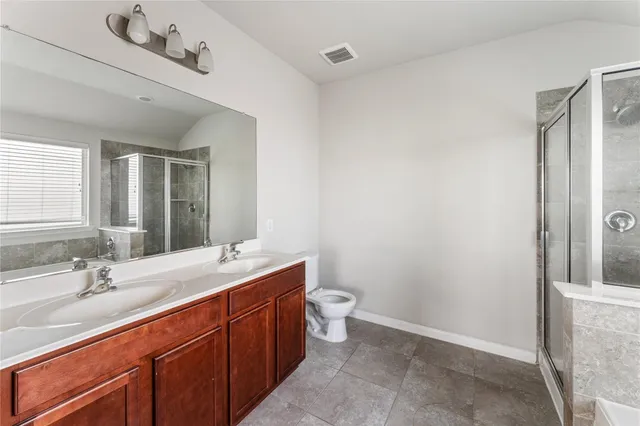 a spacious bathroom with a double vanity sink toilet and a mirror