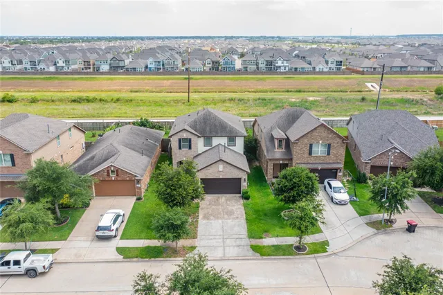 an aerial view of a house with a garden and lake view