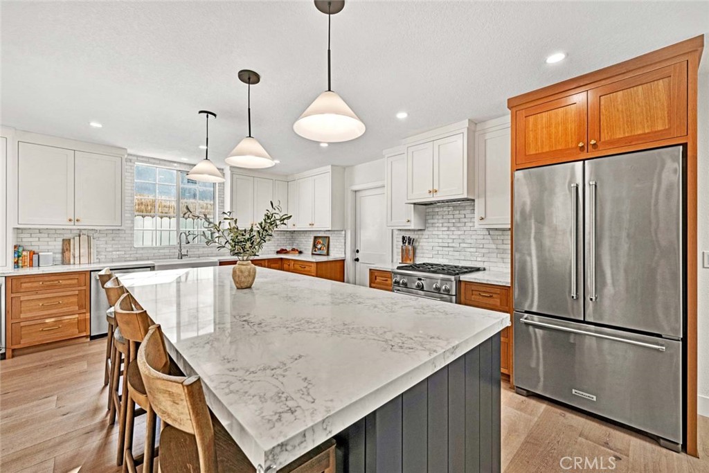 3210 Iowa Street Costa Mesa, CA 92626 - Photo 7 of 18 a kitchen with stainless steel appliances granite countertop a refrigerator a sink dishwasher a stove and a refrigerator with wooden floor