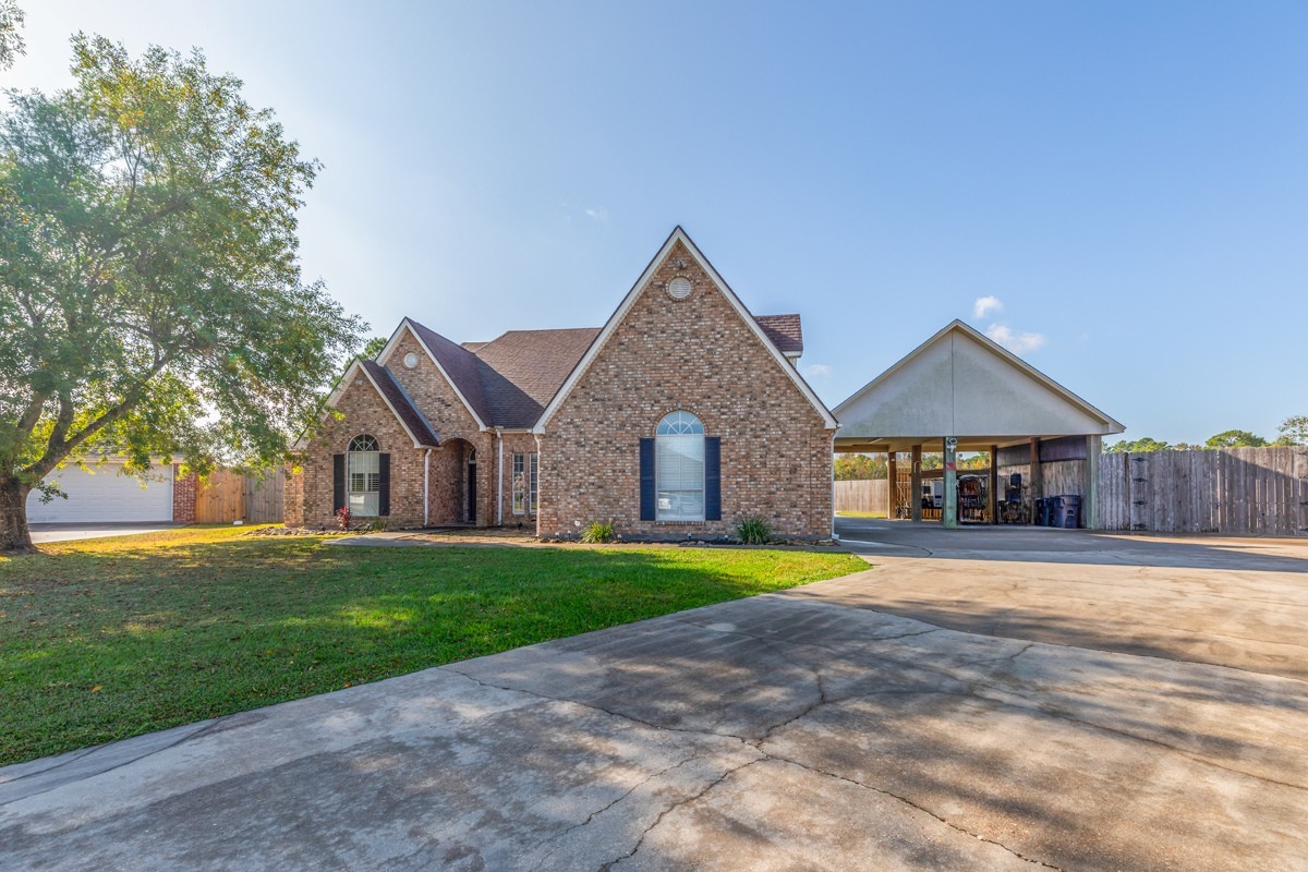 665 Winchester Drive Bridge City, TX 77611 - Photo 12 of 39 a front view of a house with a yard and garage