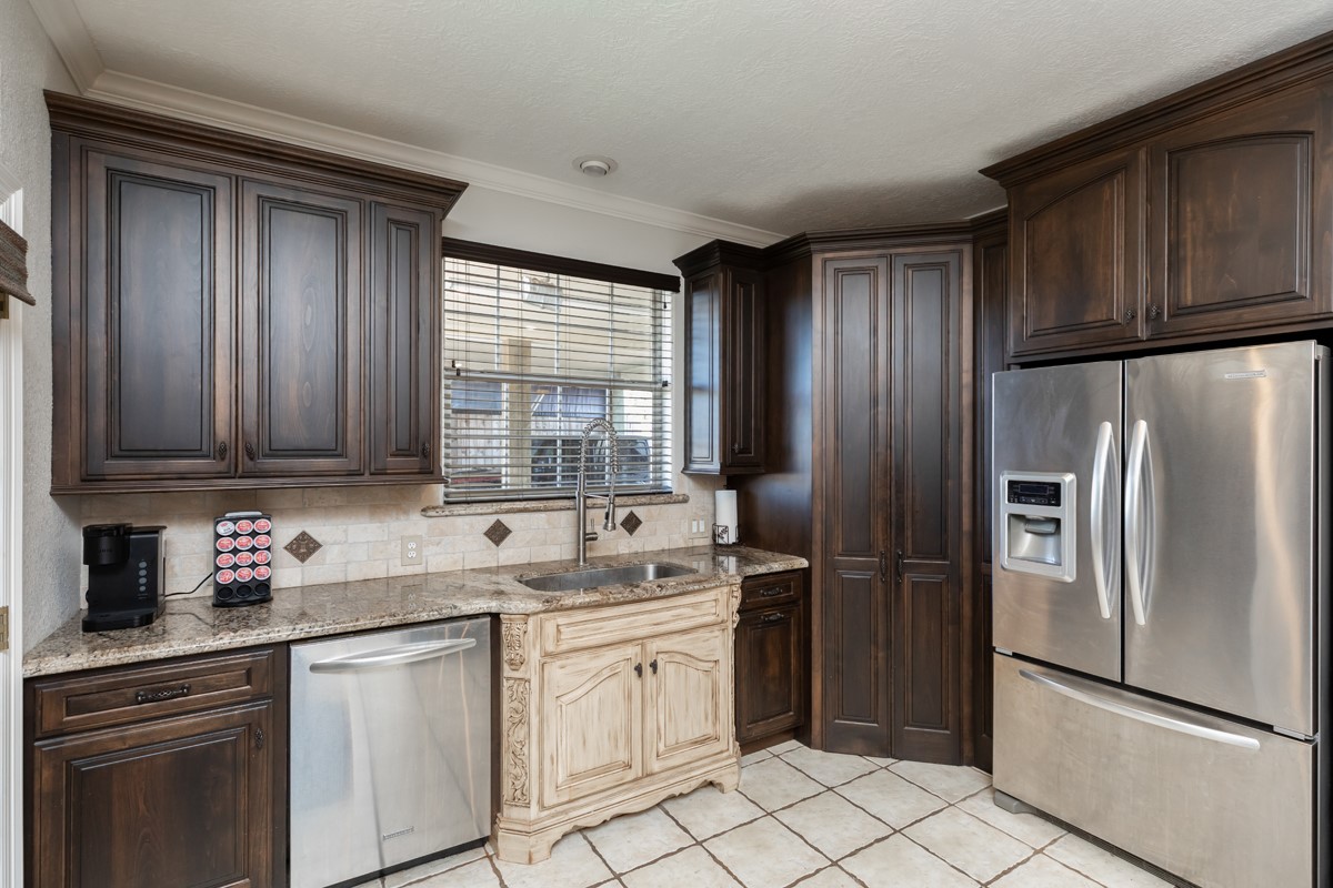 665 Winchester Drive Bridge City, TX 77611 - Photo 24 of 39 a kitchen with a refrigerator sink and cabinets