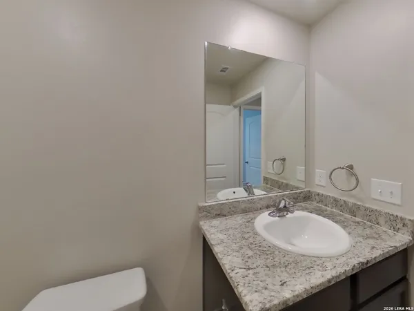 a bathroom with a granite countertop sink and a mirror