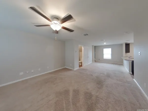 a view of a livingroom with a ceiling fan and window