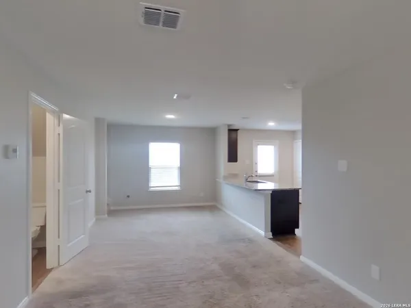 an empty room with windows and cabinet