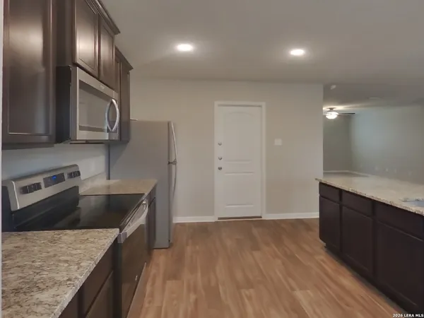 a kitchen with kitchen island granite countertop wooden cabinets and stainless steel appliances
