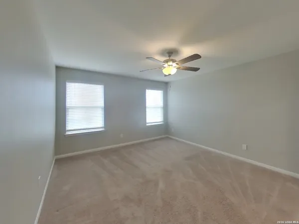 an empty room with window and chandelier fan