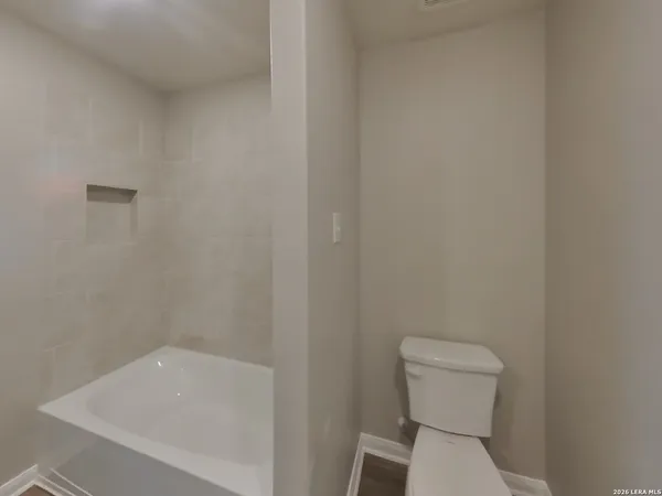 a white toilet sitting next to a white sink and vanity