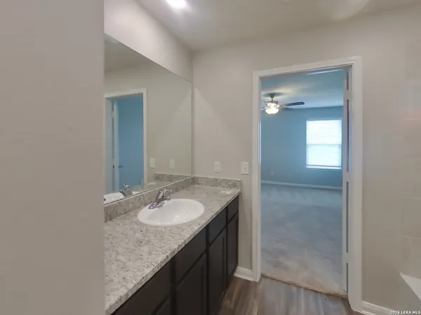 a bathroom with a granite countertop sink and a mirror