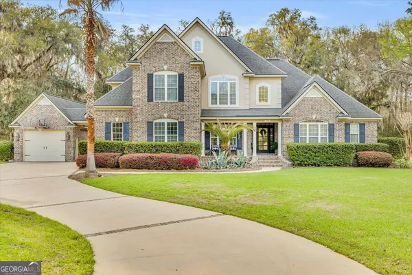 a front view of a house with a garden and yard