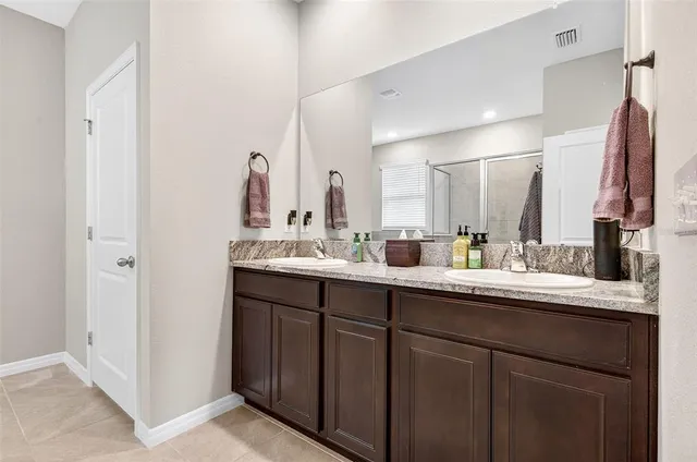 a bathroom with a double vanity sink and a mirror