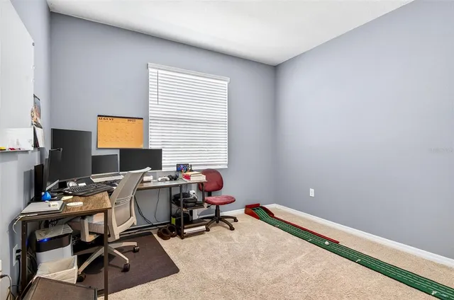 a view of a workspace with furniture and a window