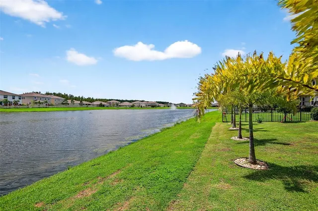 a view of a lake with a big yard and a large trees