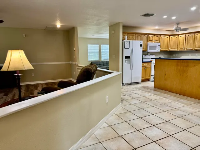 a kitchen with stainless steel appliances granite countertop a sink and a refrigerator