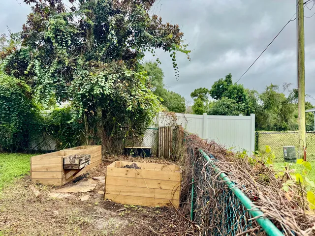 a view of a house with a yard and table and chairs under an umbrella