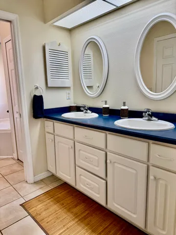 a bathroom with a granite countertop double vanity sink and a mirror