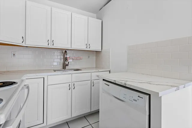 a kitchen with white cabinets and white appliances