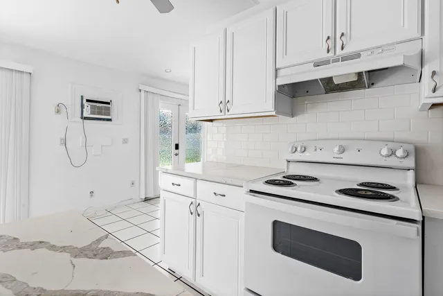 a kitchen with white cabinets and appliances