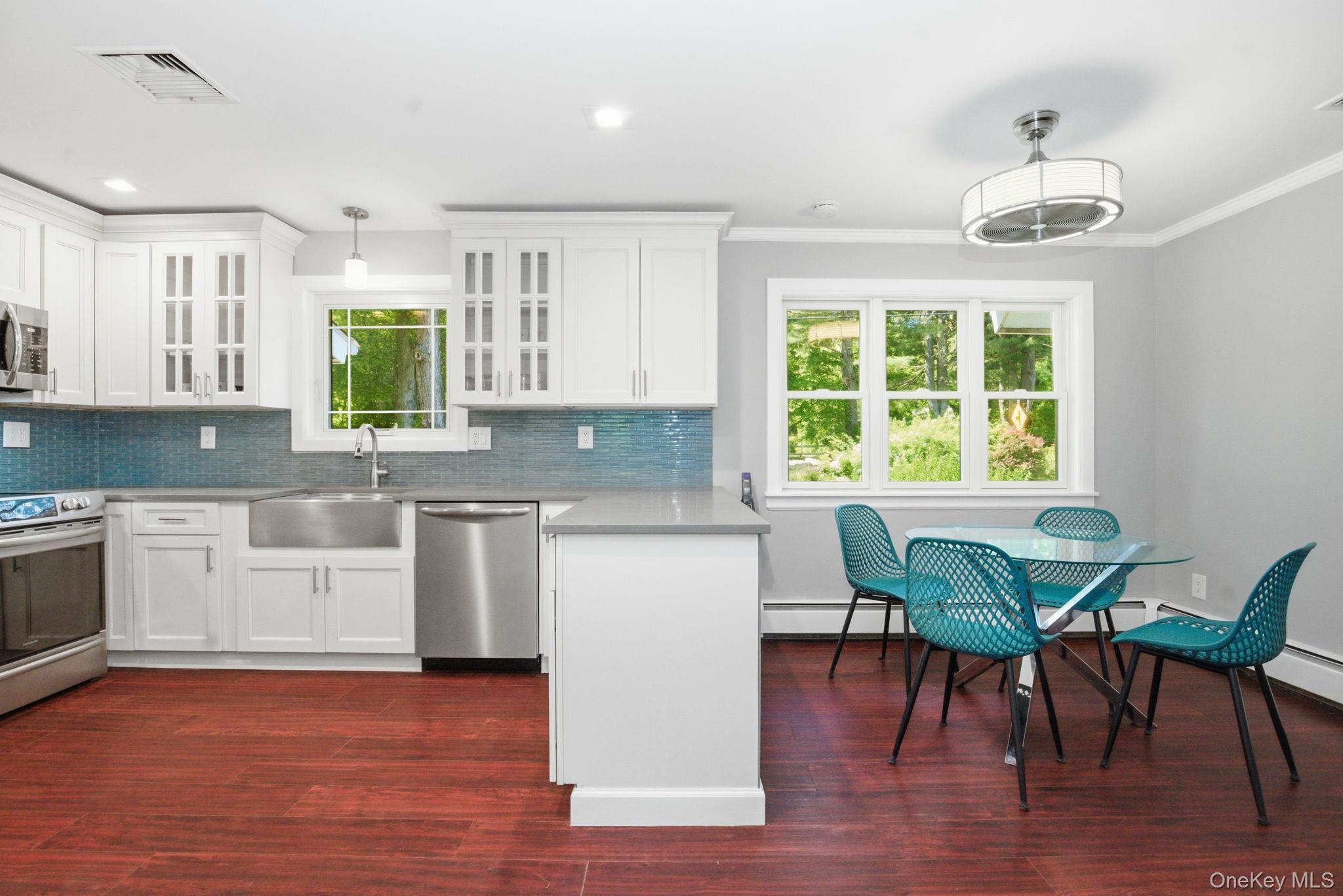35 Deans Bridge Road Somers, NY 10589 - Photo 4 of 49 The fully renovated kitchen pairs crisp white cabinetry with quartz counters and a striking glass tile backsplash.