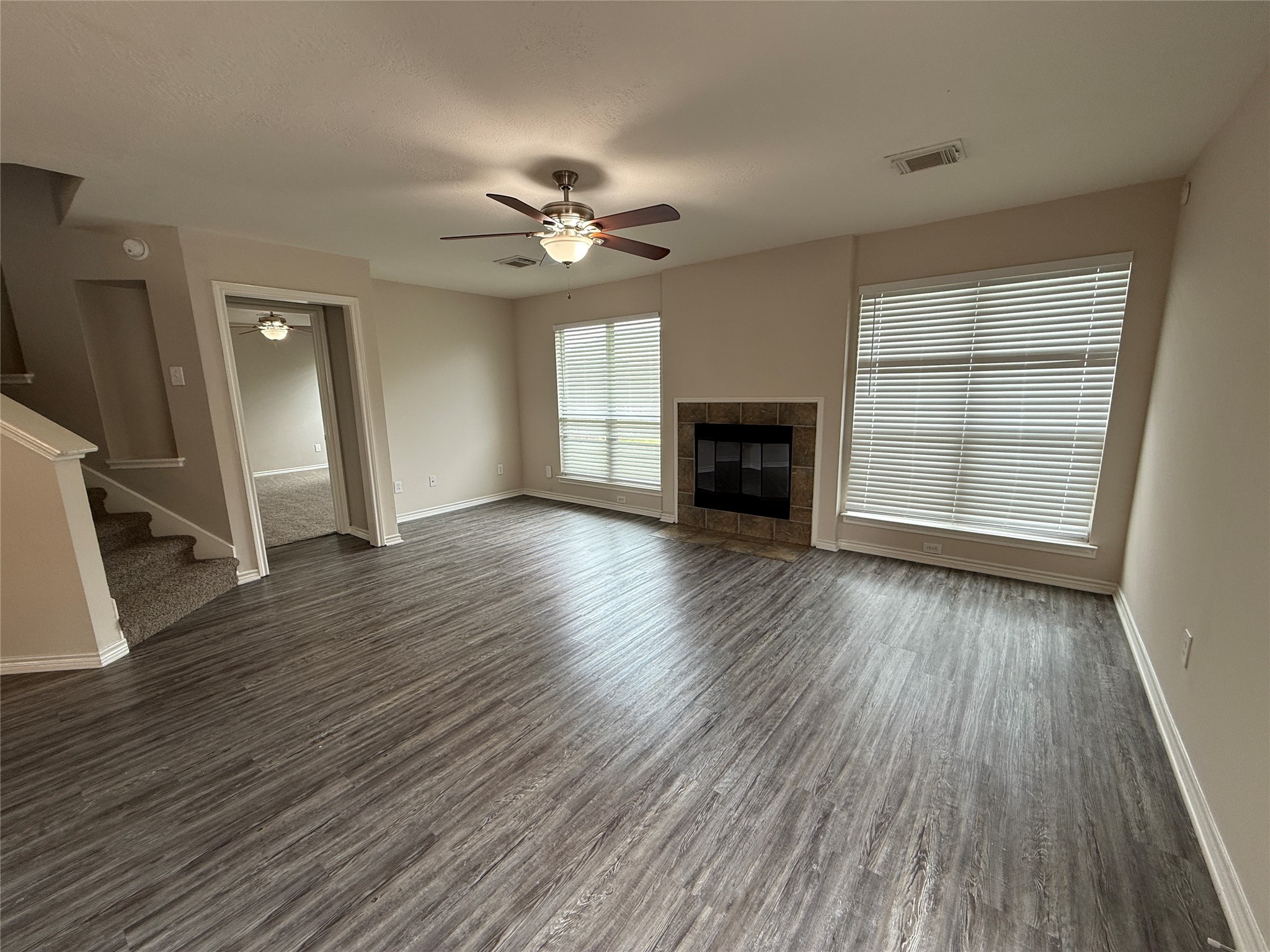 2325 Shady Tree Lane Conroe, TX 77301 - Photo 3 of 22 an empty room with wooden floor fireplace and windows