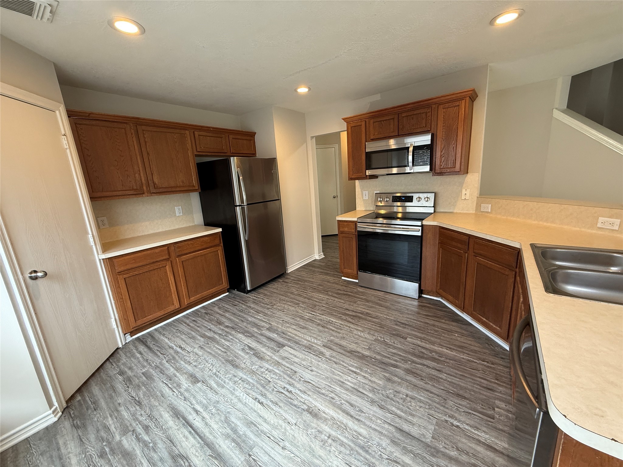 2325 Shady Tree Lane Conroe, TX 77301 - Photo 4 of 22 a kitchen with granite countertop a refrigerator stove and sink