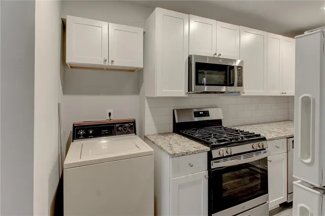 a kitchen with granite countertop white cabinets and a sink