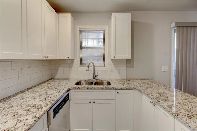 a kitchen with granite countertop cabinets stainless steel appliances and a sink
