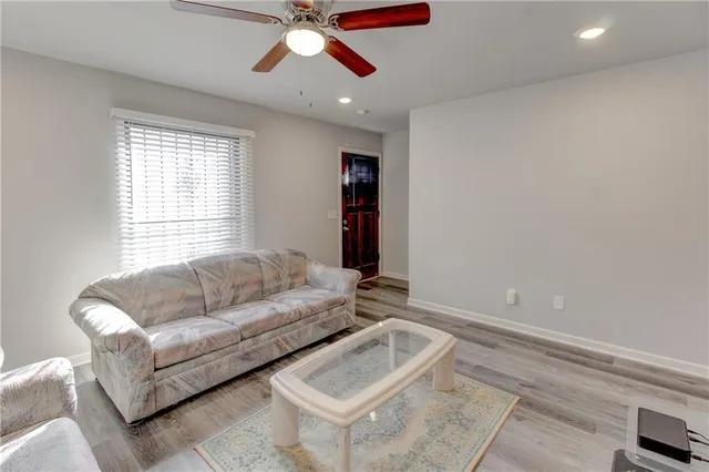 a living room with furniture and a wooden floor