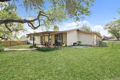 a view of a house with backyard and sitting area