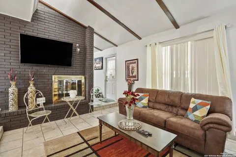 a living room with furniture a flat screen tv and a fireplace