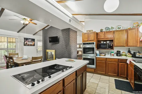 a kitchen with a stove a sink dishwasher and a microwave with wooden floor