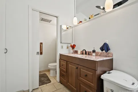 a bathroom with a sink vanity mirror and toilet