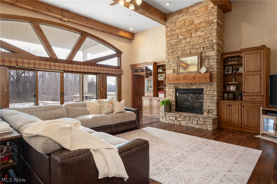 9419 Robinson Road Chardon, OH 44024 - Photo 4 of 46 Living room featuring a ceiling fan, a stone fireplace, and dark wood-type flooring