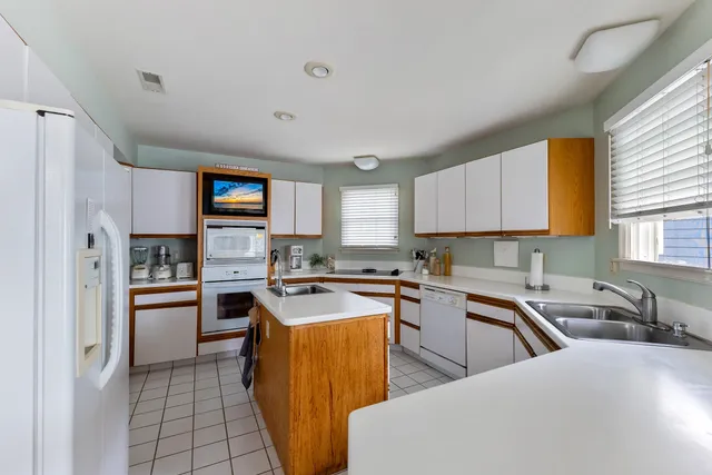 a kitchen with stainless steel appliances granite countertop a sink stove refrigerator and cabinets