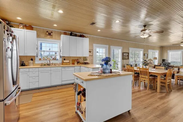 a kitchen with granite countertop white cabinets and white stainless steel appliances
