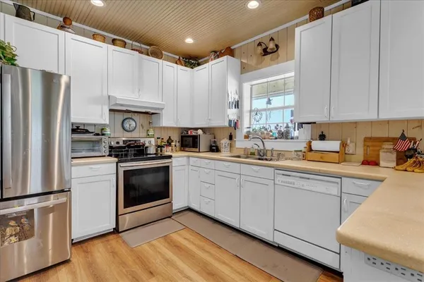 a kitchen with a sink a refrigerator and cabinets