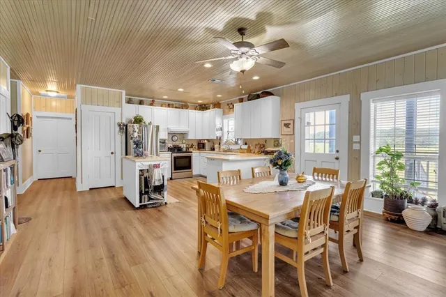 a view of a dining room with furniture a chandelier and wooden floor