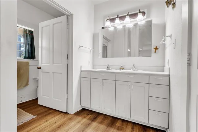 a view of a hallway with wooden floor and a living room