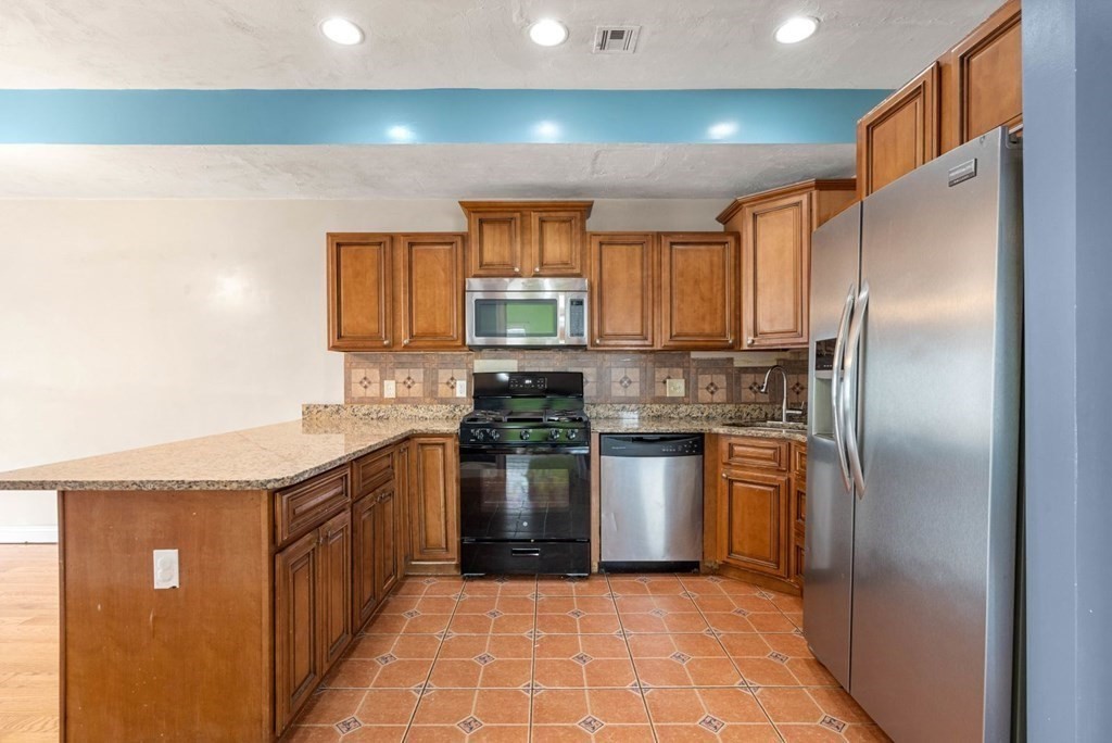 a kitchen with stainless steel appliances granite countertop a refrigerator a sink a stove and island