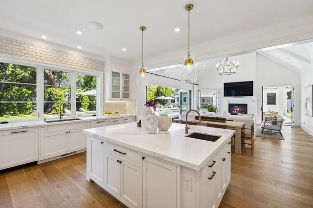 a kitchen with granite countertop a sink cabinets and wooden floor