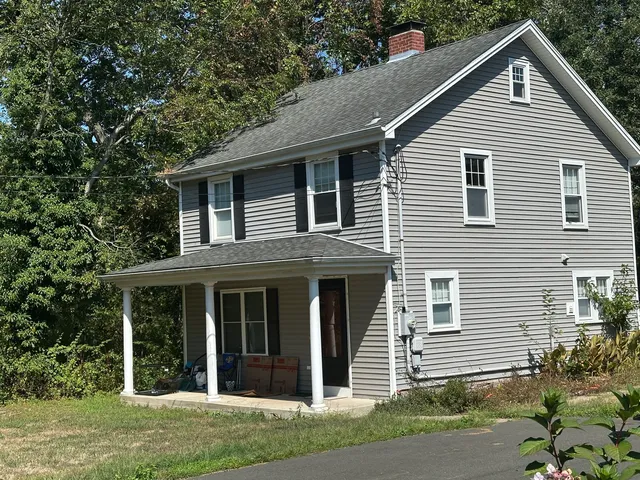 a front view of a house with a yard and potted plants
