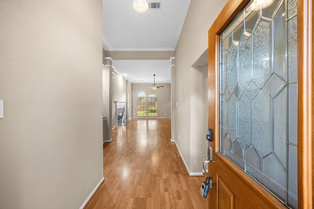 a view of a hallway with wooden floor and a bathroom