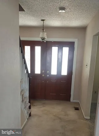 an empty room with staircase and windows