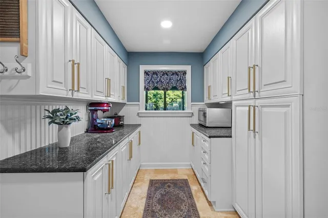 a bathroom with a granite countertop sink mirror and cabinets
